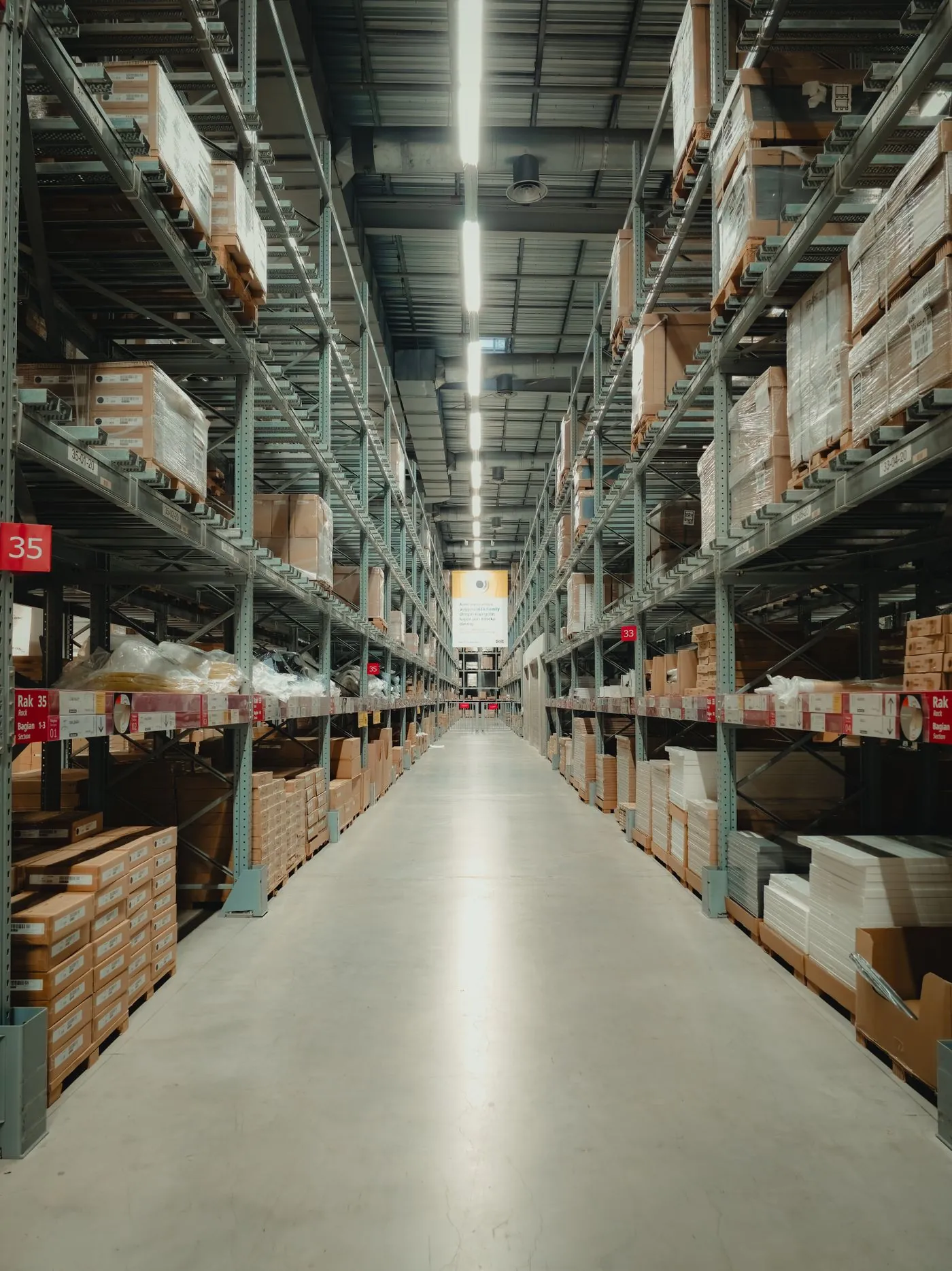 A long warehouse aisle lined with pallet racking.